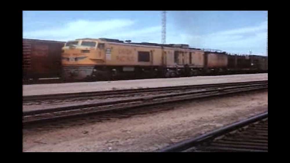 Yellow locomotive on freight train in yard
