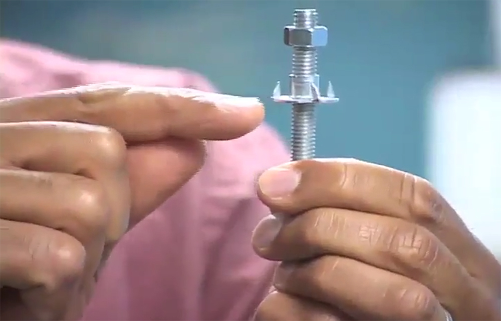 Hands holding and pointing to a large screw and nut