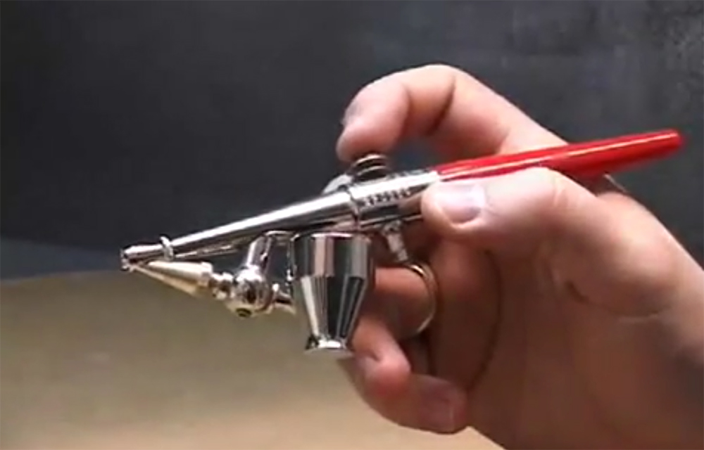 Hand holding an airbrush