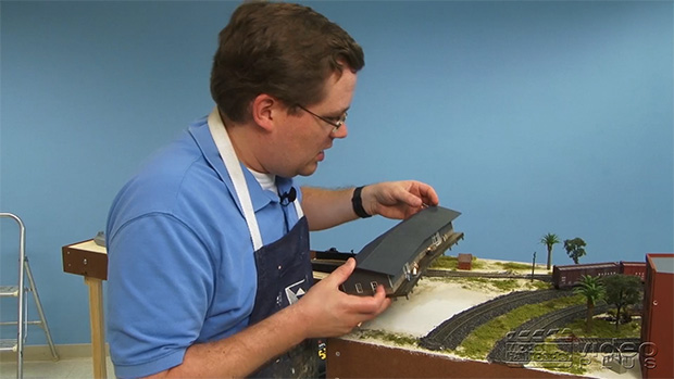 Cody Grivno placing a structure on a model railroad