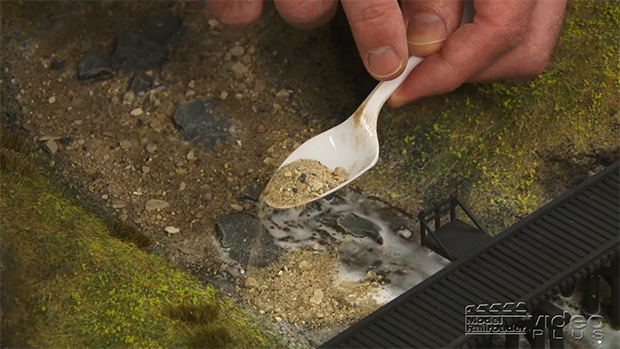 David laying sand with a spoon.