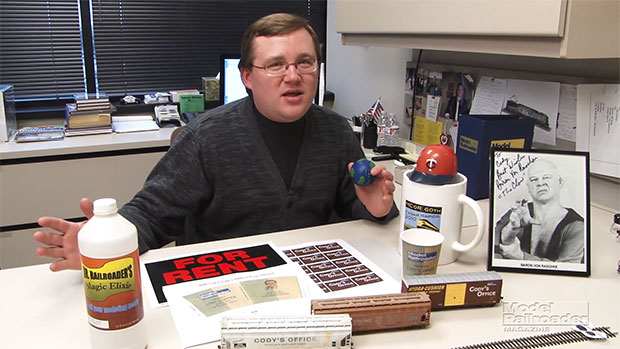 Cody sitting at his desk with products in front of him