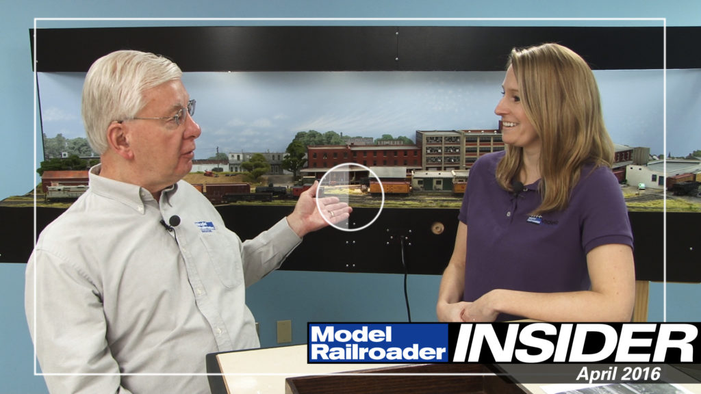 Tony Koester and Jenny Freeland having a conversation in front of a model railroad layout