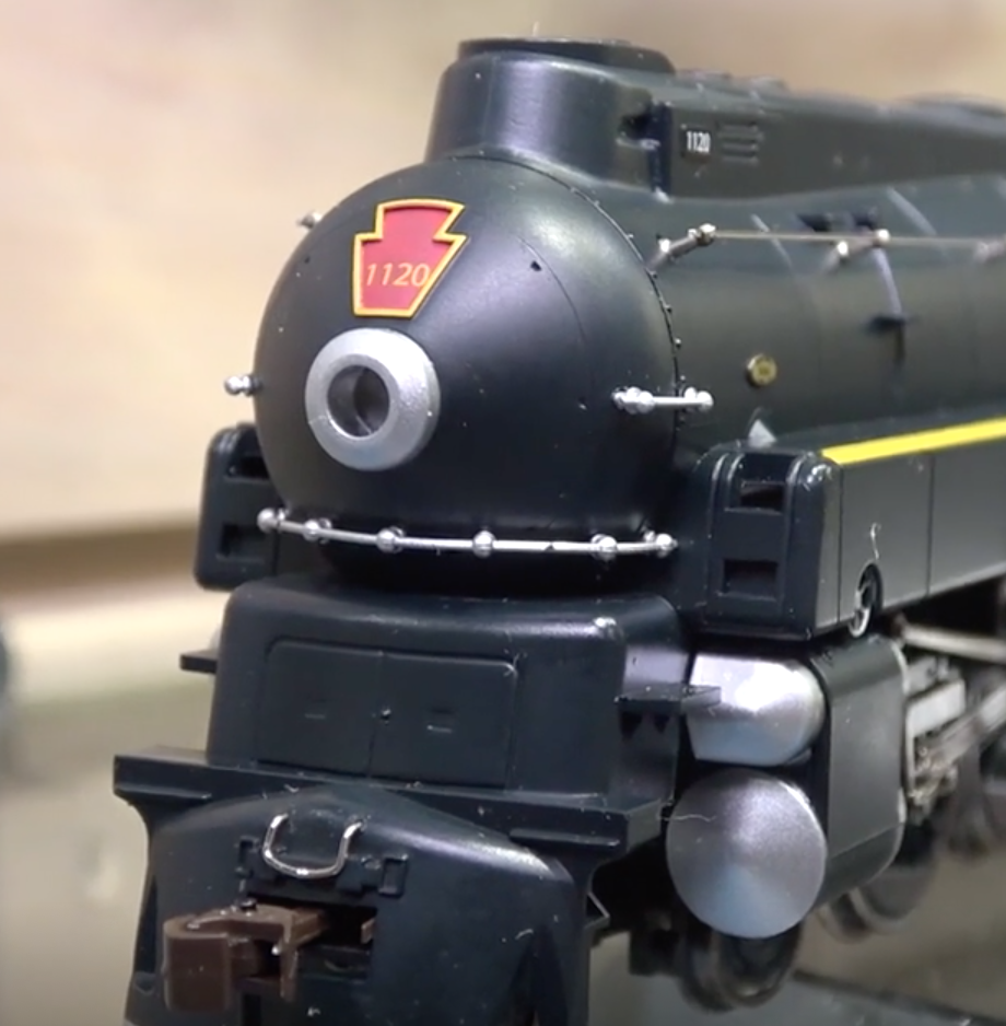 Close view of a black, streamlined, model train steam locomotive.