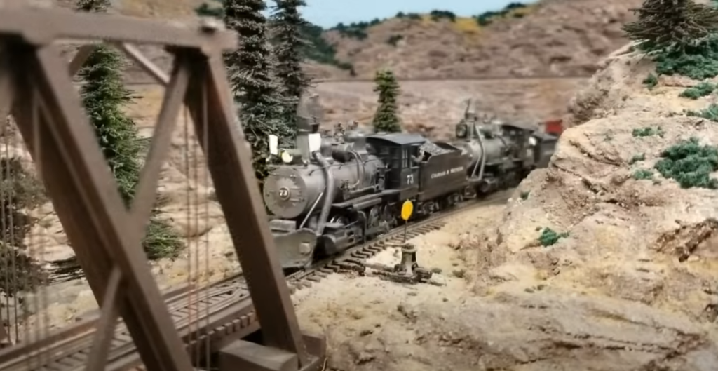 Model locomotive heading toward a bridge