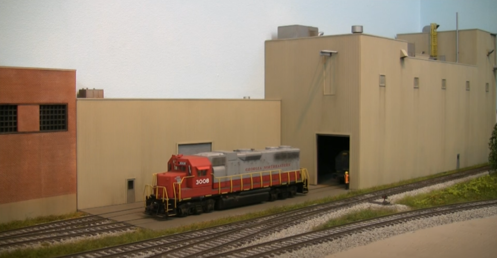 Model locomotive next to building