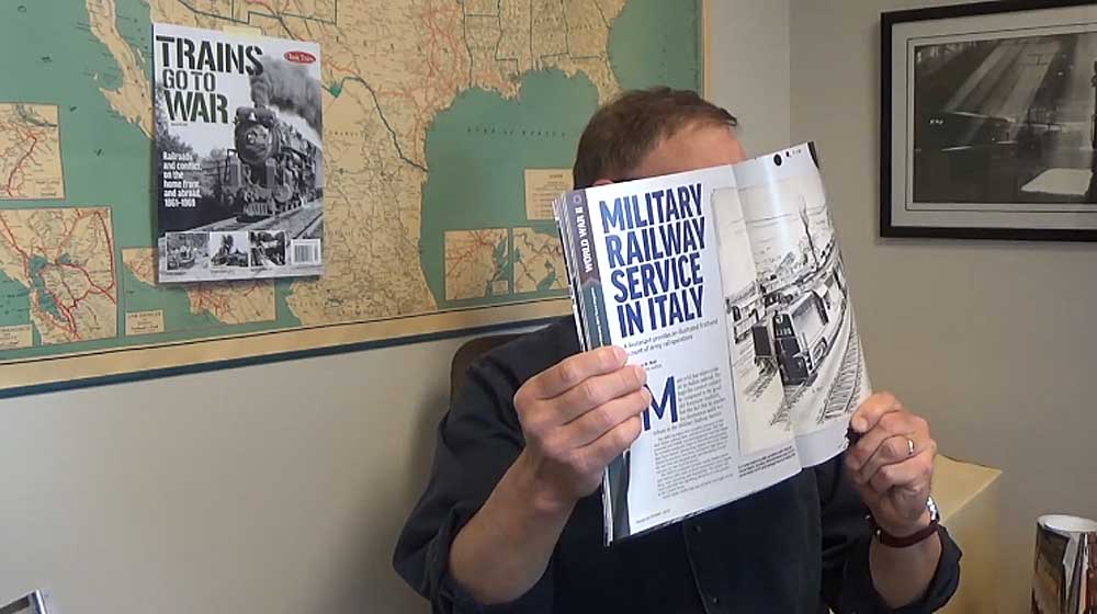 Person holding magazine in front of wall map