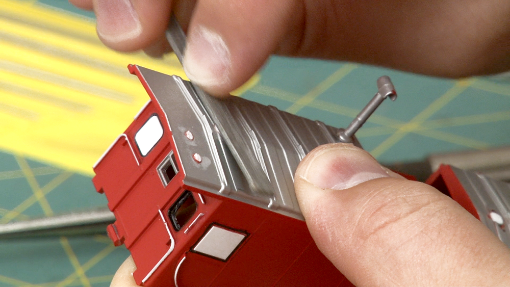 The roof of a model caboose getting filed down