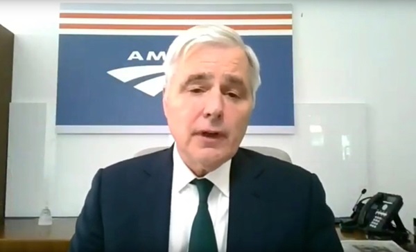 Man with white hair and dark colored business suit.