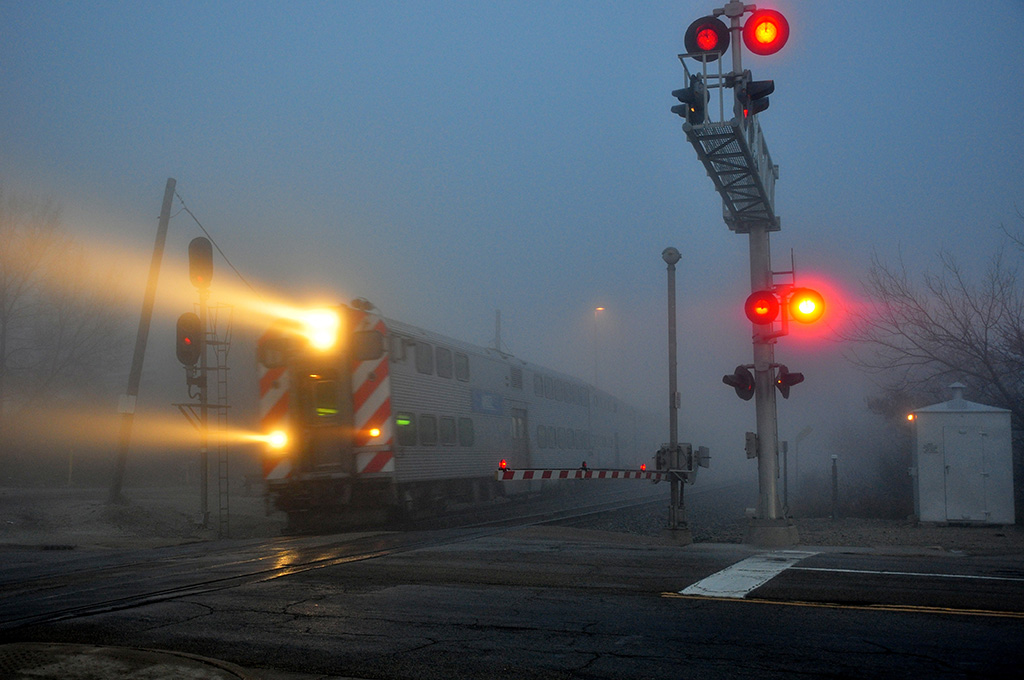 A metra train passing through a stop light