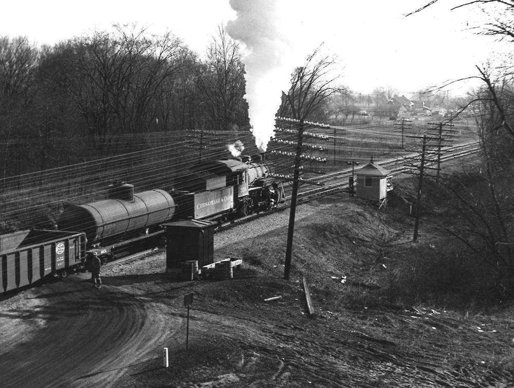 A black and white photo of the Chesapeake & Ohio No. 350 locomotive leaving the rail yard with white smoke coming out of its chimney