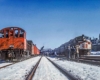 Diesel locomotives pass in snow