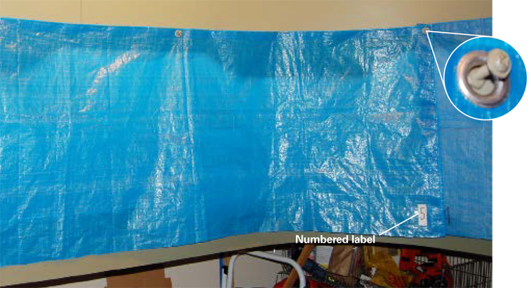 Fig3TarpcurtainsToshieldthelayoutfromdustHowardusescurtainsmadefromblueplastictiedowntarpsThetarpshavegrommetsalongtheiredgeswhichHowardhangsfrommachinescrewsinthevalance