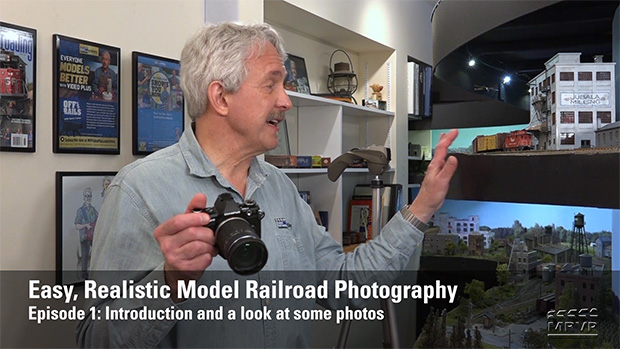 Gerry Leone holding a camera in front of his layout.