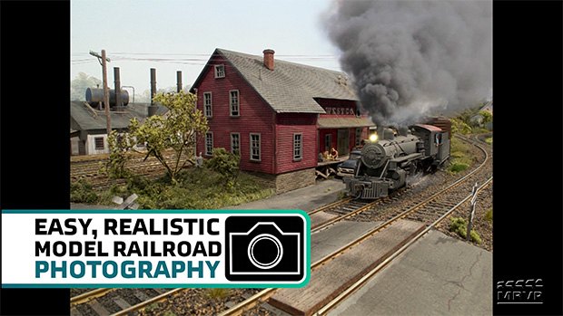 Model train going past a building.