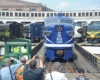 People taking pictures of a train on a turntable