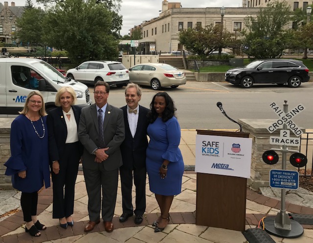 Five people posing next to podium at safety event