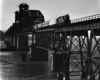 Diesel locomotive with three passenger cars on large bridge