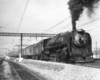 Steam locomotive with passenger train under catenary