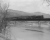 Steam locomotive with passenger train on bridge