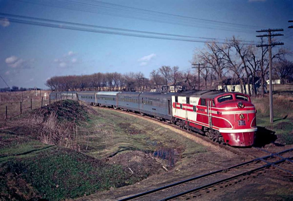 A red train approaching an intersection