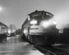 Passenger train along platform on foggy night