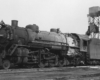 A black and white photo of a 2-8-2 steam locomotive on the tracks