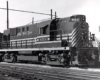 A close up black and white photo of a road-switcher diesel locomotive in a rail yard