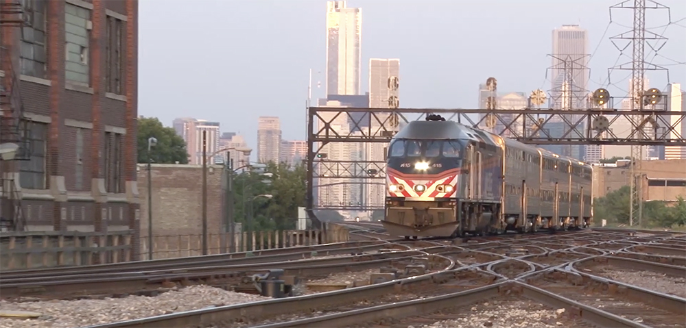 A Metra passenger train speeds north with downtown Chicago in the background.