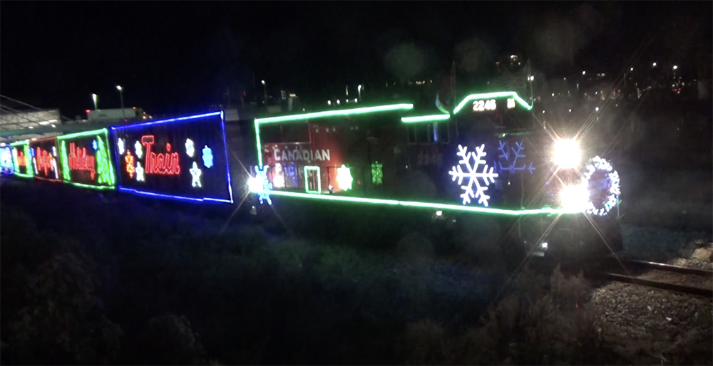 Green, white, red, and blue party lights decorate the outlines of a locomotive and train.