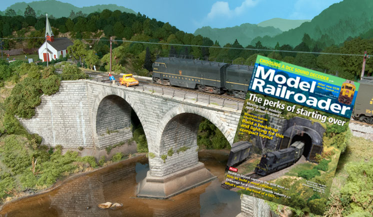 model train traveling over a bridge and the cover of an issue of Model Railroader magazine