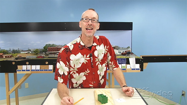David Popp wearing a Hawaiian shirt and standing behind a table with a Tortoise motor switch on it.