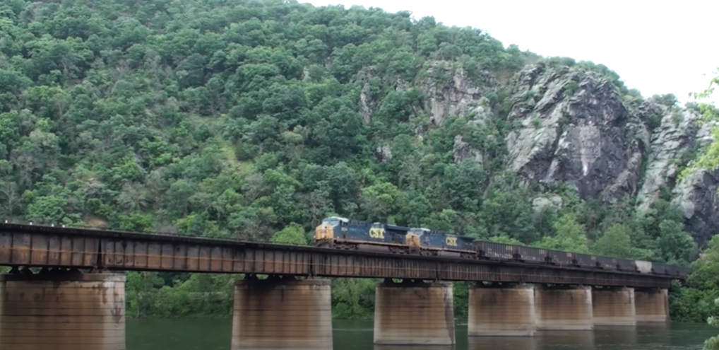 CSX locomotives pull freight cars on a bridge over the Potomac River