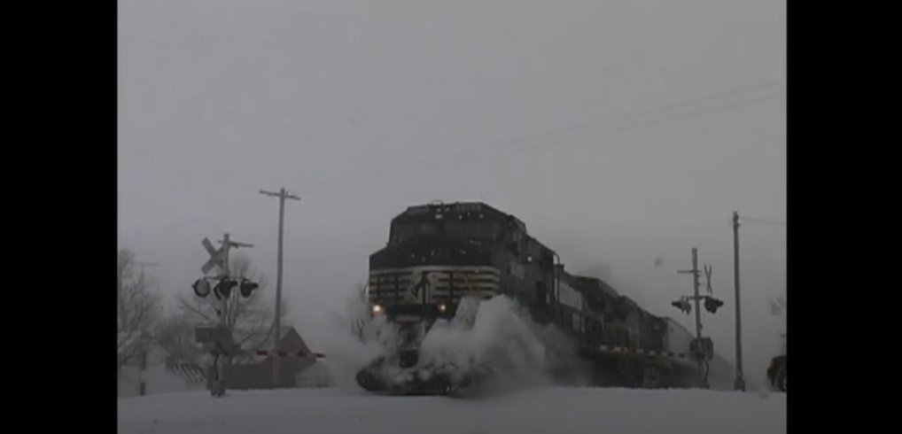 Train approaching a crossing in the snow