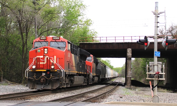 Red and black locomotives leading train under bridge