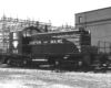 Black painted early diesel locomotive pausing in a rail yard.