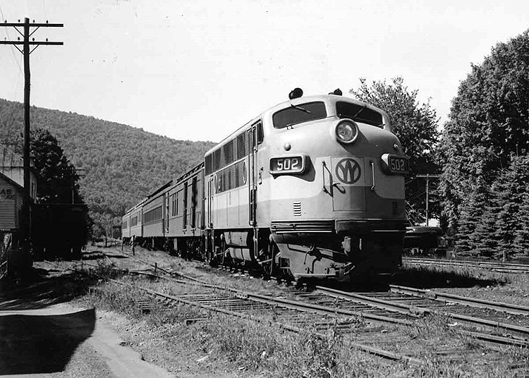 Cab unit diesel locomotive leads a passenger train.