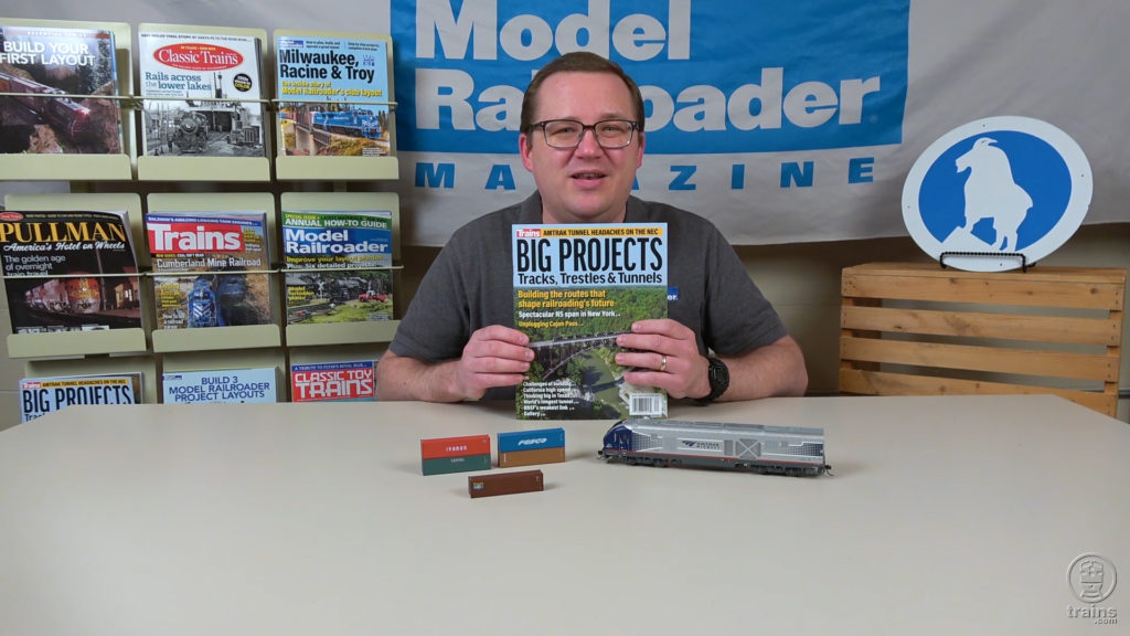 Cody Grivno sitting at a table with a display of new model railroad products