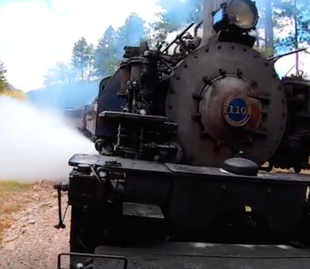 Close view of steam locomotive emitting steam.