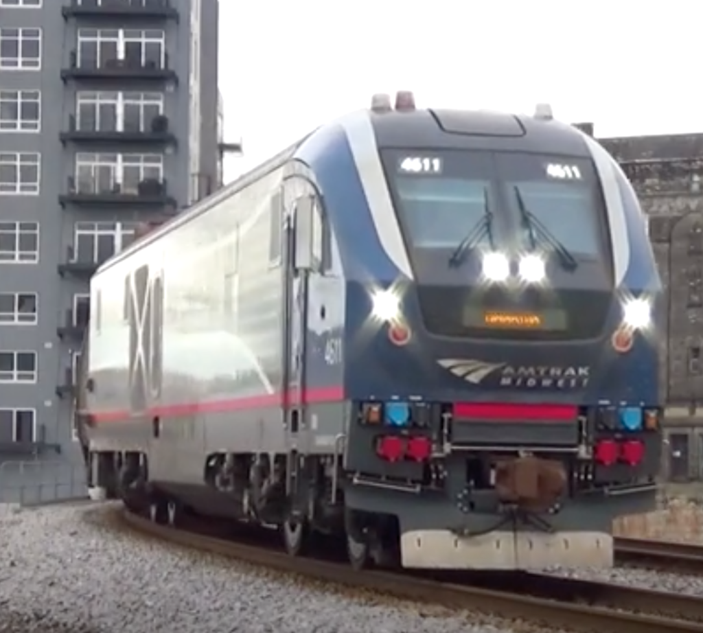 Diesel electric locomotive leading a train over a bridge.