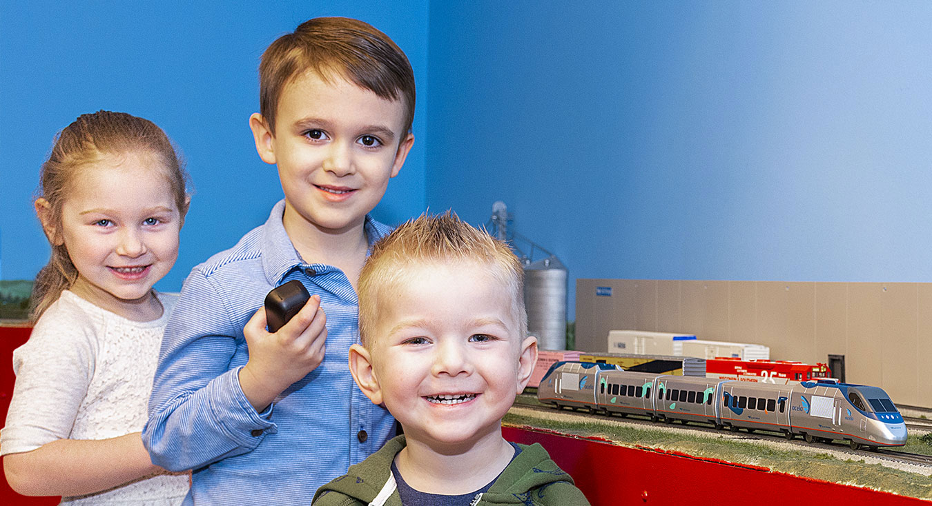 Three children standing by a HO scale layout