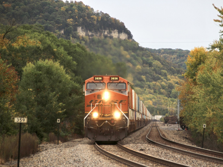Intermodal train approaching curve with bluffs in background