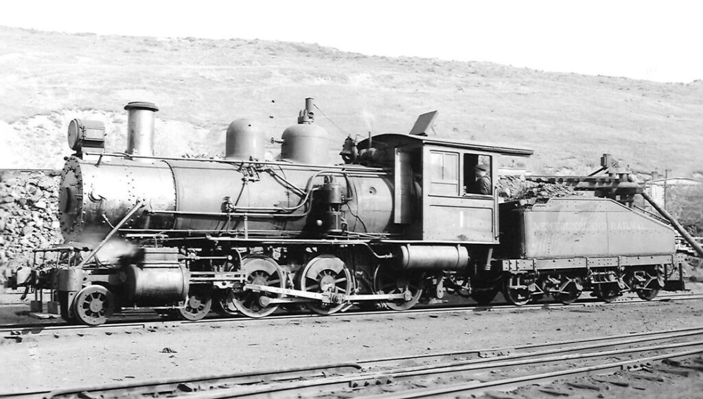 Old 4-6-0 steam locomotive resting in a rail yard.