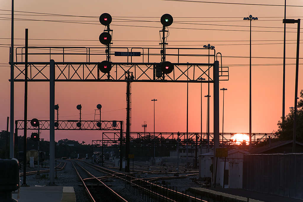 Sunset over a rail yard and signals.