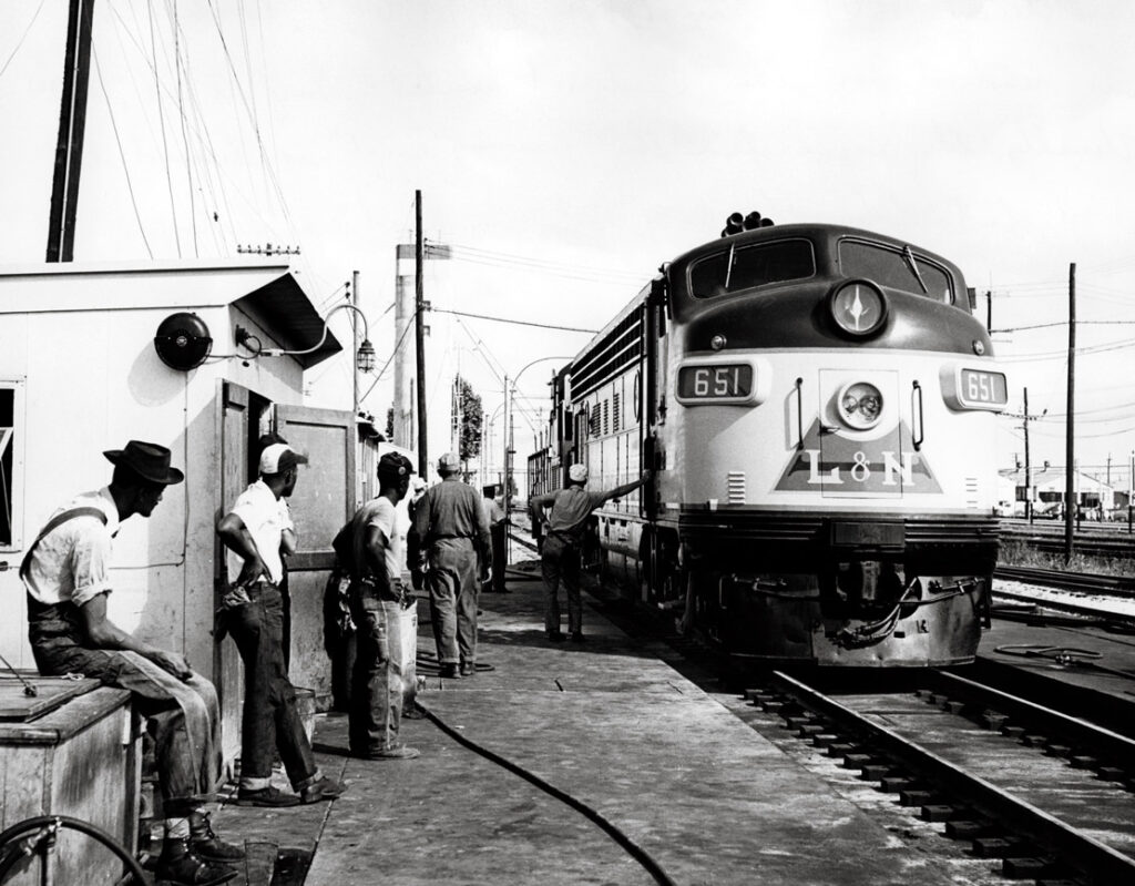 Workers with two passenger diesel locomotives