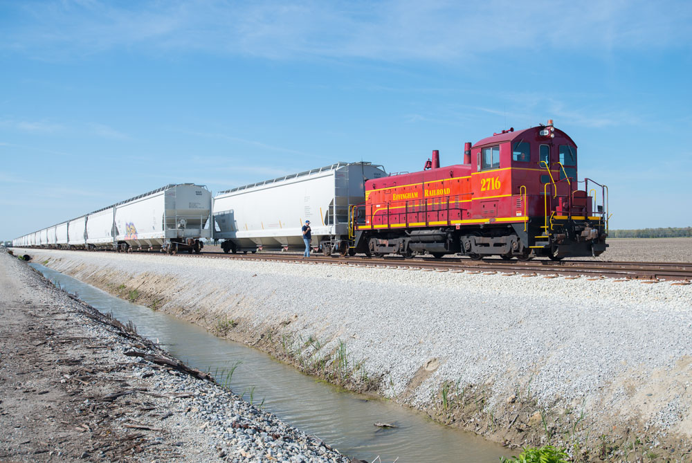 Red diesel locomotive switching freight cars.