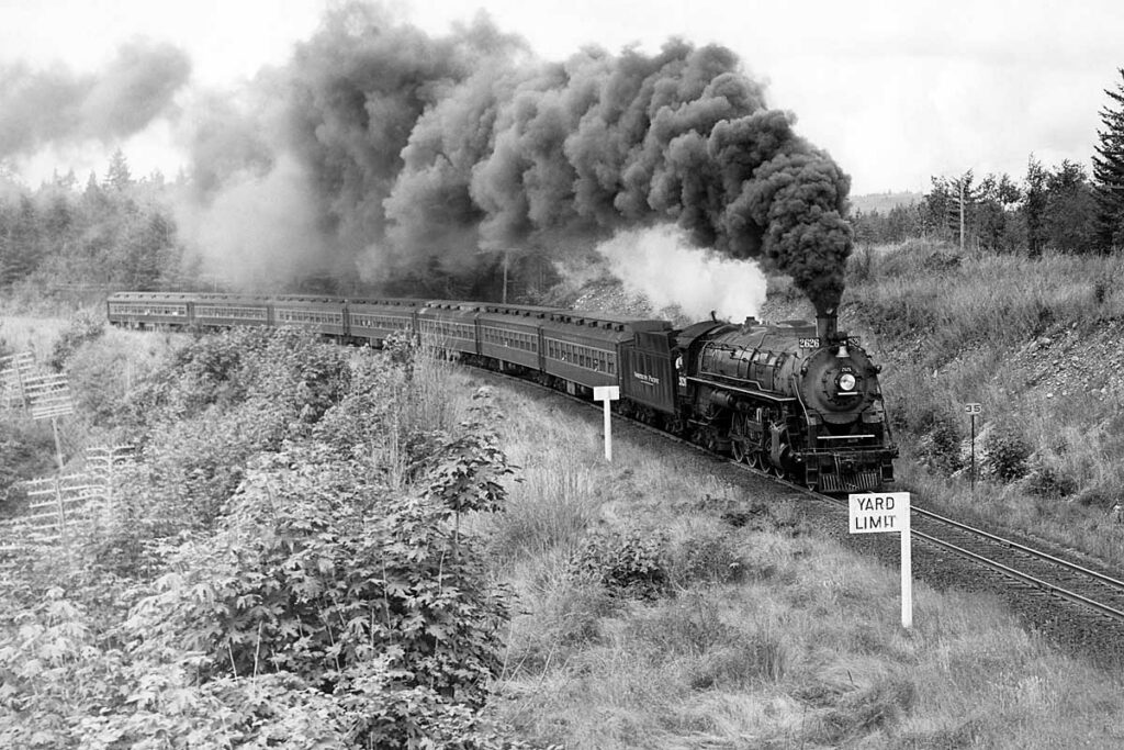 Steam locomotive smoking with passenger train on curve