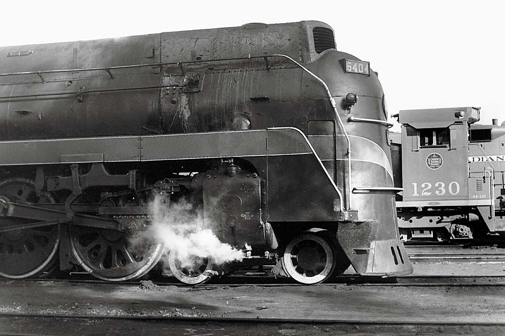 Streamlined steam locomotive in front of box-like diesel locomotive