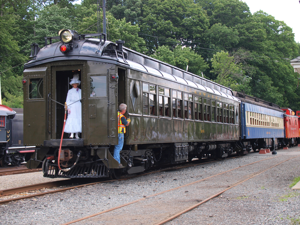 Pullman green passenger car with woman in front vestisbule