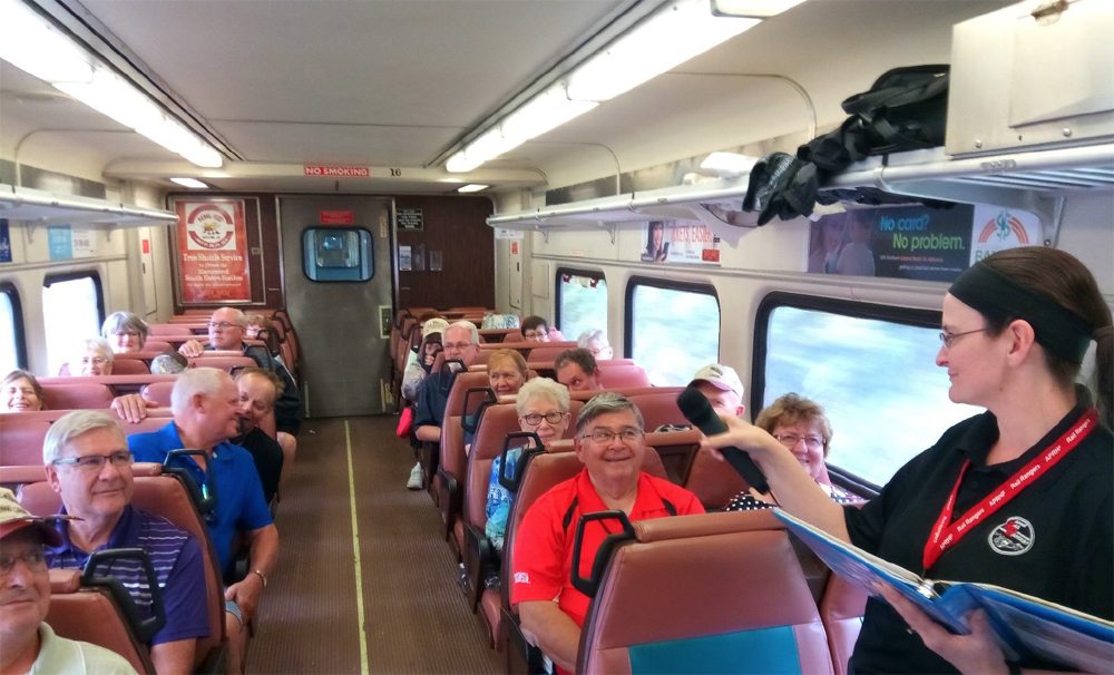 Woman speaking to railcar full of passengers